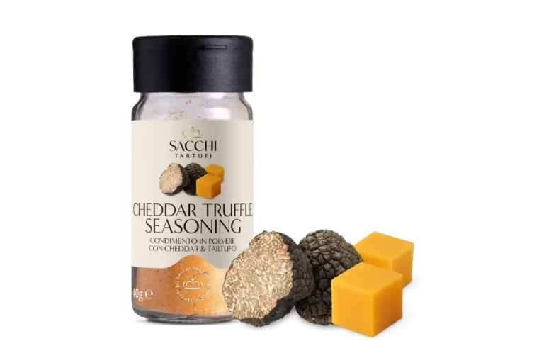 Sacchi Cheddar Truffle Seasoning jar with black lid next to two sliced truffles and yellow cheese cubes