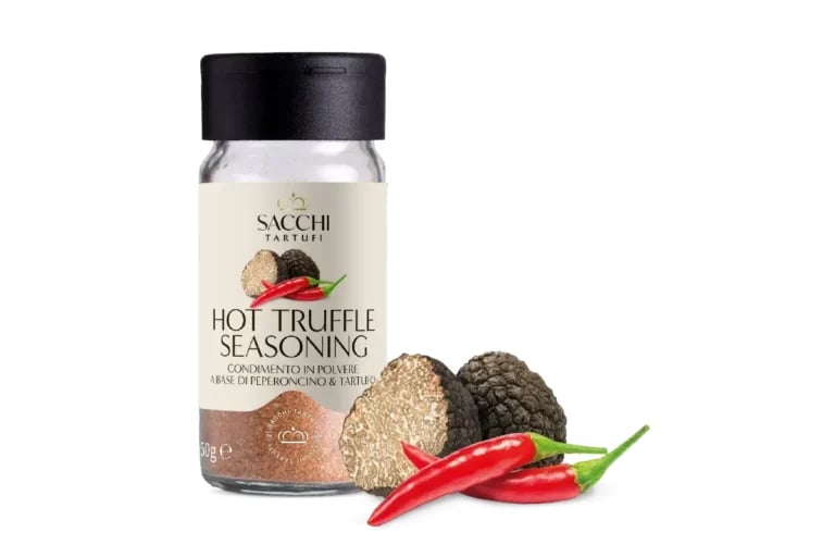 Sacchi hot truffle seasoning jar with black cap, displayed with truffles and red chili peppers